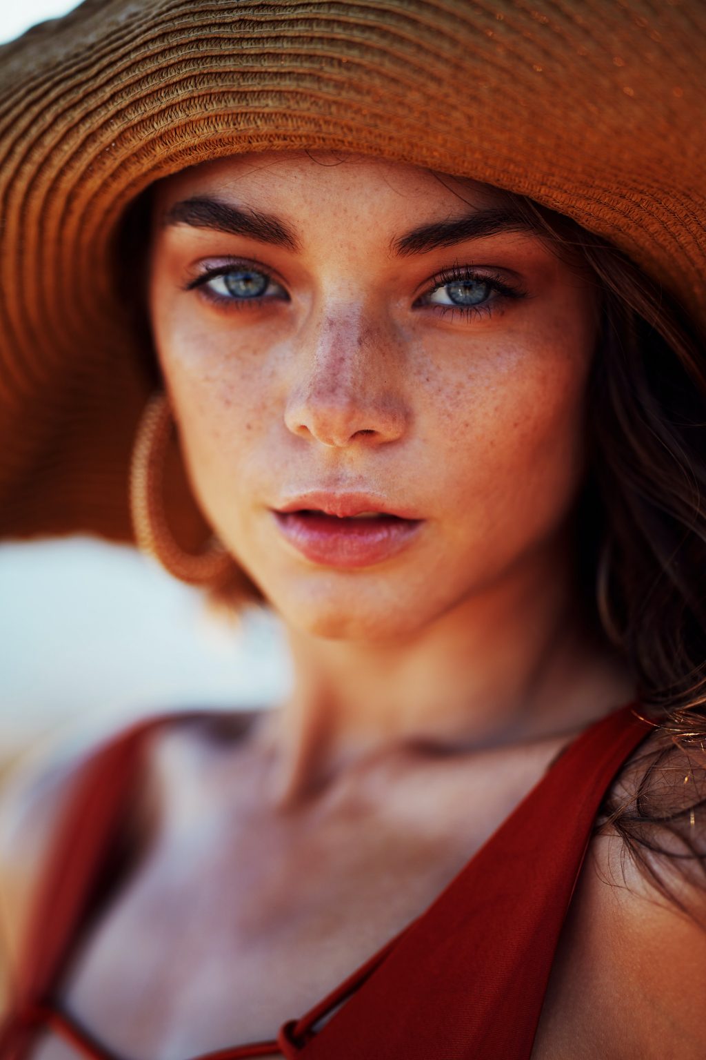 Das Bild zeigt eine junge hübsche Frau mit Sommersprossen und heller Haut.